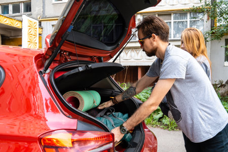 Young couple putting luggage for camping in carの写真素材
