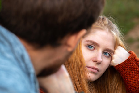Portrait of attractive young woman looking at her boyfriend outdoorsの写真素材