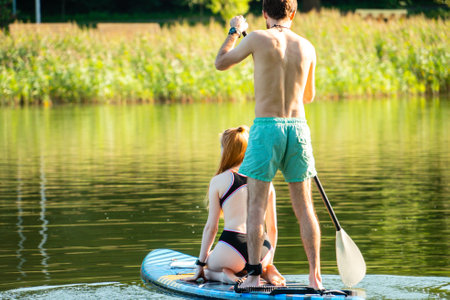Young couple swimming on paddleboardの写真素材