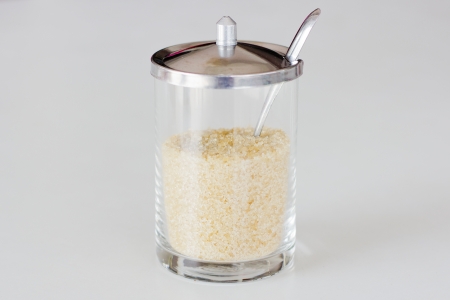Jar with a white sugar isolated on whiteの写真素材