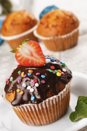 Chocolate muffin with strawberry on top on the white plateの写真素材