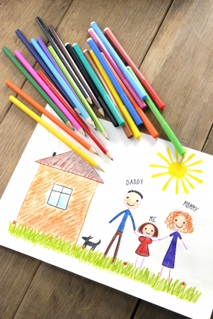 kids drawing happy family near their house picture on the wooden tableの写真素材