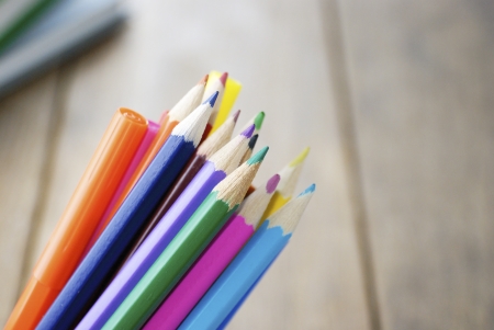 Lot of the rainbow pencils and felt-tip pens on the wooden tableの写真素材