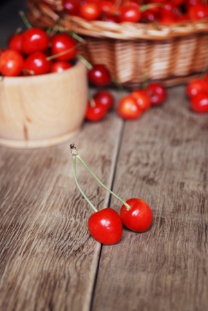 Bowl with cherries on the wooden tableの写真素材