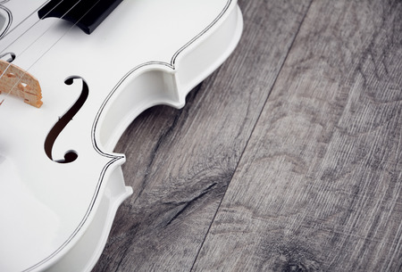 Beautiful white violin on the wooden tableの写真素材