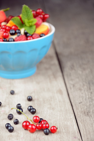 Fresh tasty fruit salad in the bowl on the wooden tableの写真素材
