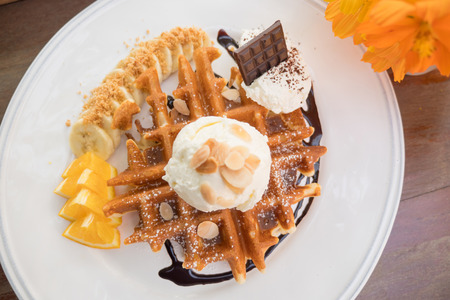 waffles with banana, orange and ice cream on white plate. Top viewの写真素材