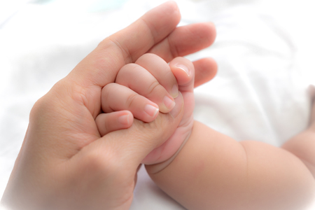 close-up hand of baby in the hand of mother.の写真素材