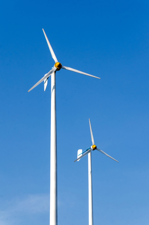 Wind turbines on the beautiful nature generating electricity with blue sky - energy conservation conceptの写真素材