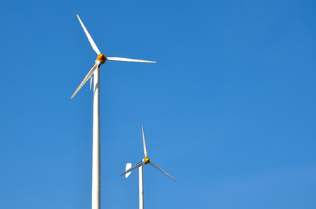 Wind turbines on the beautiful nature generating electricity with blue sky - energy conservation conceptの写真素材