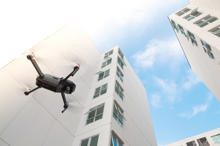 Drone with high resolution digital camera flying over on residential building background.の写真素材