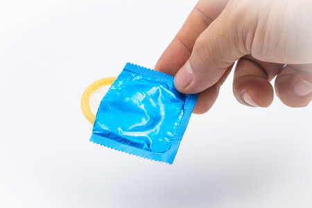 Hand with condom isolated on a white backgroundの写真素材