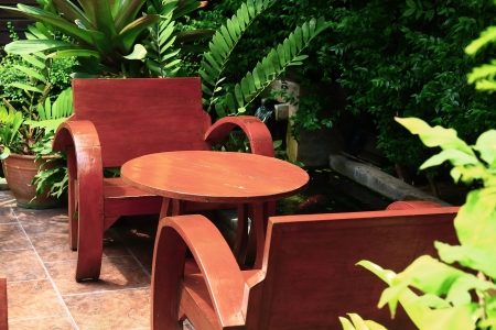 Chairs and table on wooden balcony in a green plant garden. の写真素材