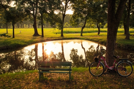 Bicycle with Beautiful Summer Sunset Reflected in Still Waters of Lake の写真素材