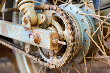 Old dirty motorcycle chain on wheel with rusty metal parts.の写真素材