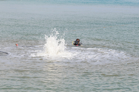 Aaqualung blowing sand in sea for pillars.の写真素材
