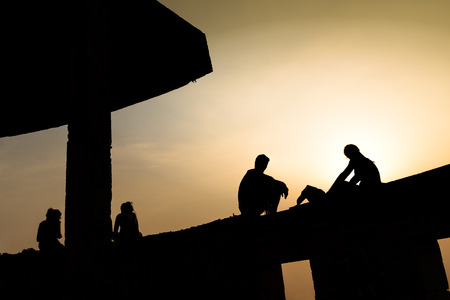 Silhouetted of couple enjoying with cityscape view at sunset.の写真素材