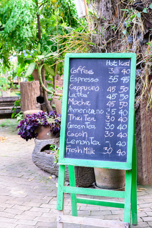 Coffee menu hand written in English with chalk on green frame blackboard.の写真素材