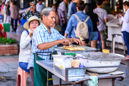 BANGKOK, THAILAND - 2015 November 15: Unidentified man hawker making banana grill for selling at street side in Bangkok, Thailand.のeditorial素材