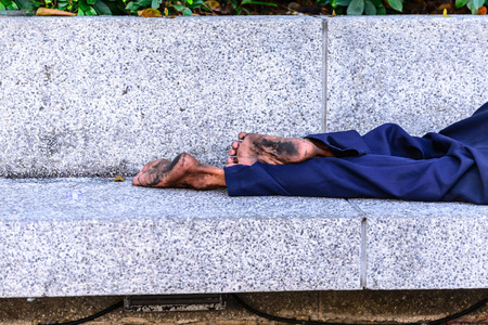 Homeless people sleeping at streetside in city.の写真素材