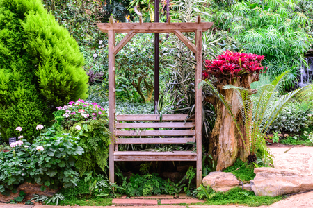 Wooden bench among the flower garden.の写真素材