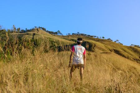 Marathon runner in 42.195 K.M. finisher t-shirt proudly standing on mountain.の写真素材