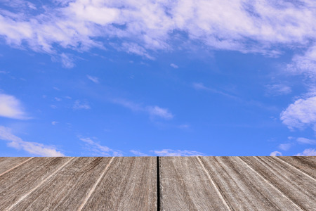 Vintage style wooden floor perspective with blue sky and clouds background.の写真素材