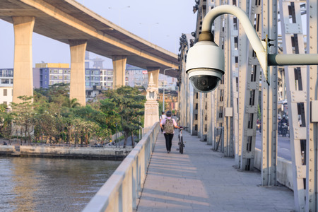 Security camera monitoring events at walk path on bridge in city.の写真素材