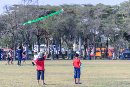 Kids flying a kite at Sanam Luang in Bangkok, Thailand.の写真素材