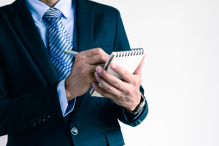 Closeup of businessman writing on packet notebook.の写真素材