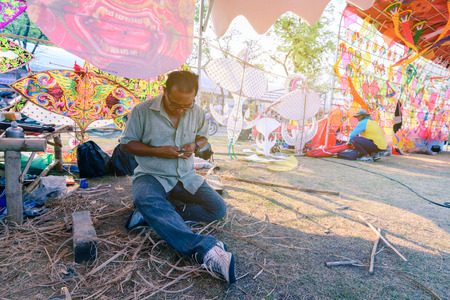 BANGKOK, THAILAND - 2016 April 21: Unidentified kite maker working on a kite in his workshop at the kite festival in Bangkok.のeditorial素材
