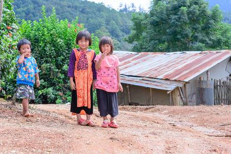 CHIANG MAI, THAILAND - 2015 November 04: Unidentified Lisu girls and boy standing together near old bamboo house, Lisu tribes live in northern of Thailand.のeditorial素材