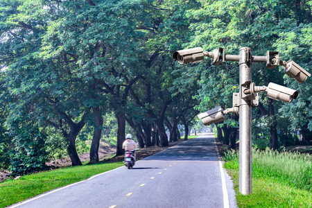 Security camera for monitring a road with shadow of tree tunnel.の写真素材