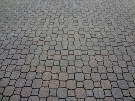 A uniformly patterned brick paving textured background.