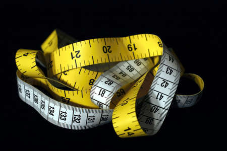 Imperial and Metric measuring tape on a black background 