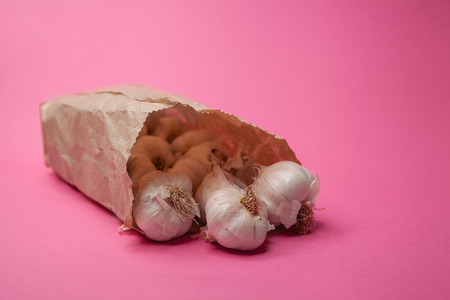 garlic in a bag from a market, store isolated on pink backgroundの写真素材