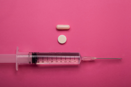 syringe and pills isolated on pink backgroundの写真素材
