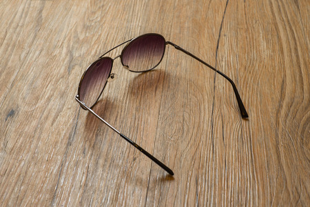 Black sunglasses on wooden floor background.の写真素材