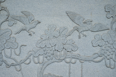 Birds carved on stone wall in Chinese temple located in Thailand.の写真素材
