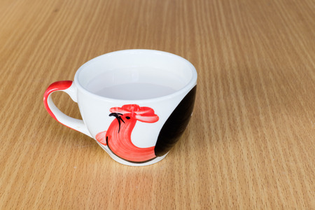 A tile cup containing a hot white milk on wooden table background.の写真素材