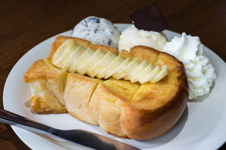 Honey toast bread serve with banana, ice cream and whipped cream.