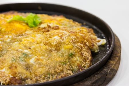 Fried oysters with egg and flour on hot plate の写真素材