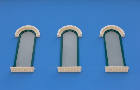 Three windows on blue wall の写真素材