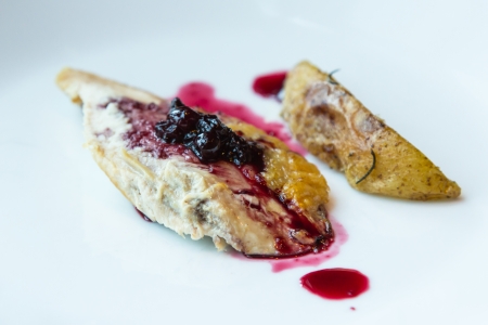 Roast chicken with blueberry sauce on white plate の写真素材