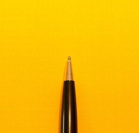 Closeup pen on yellow background の写真素材