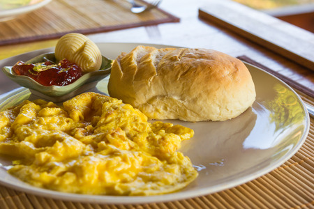 Scrambled eggs on dish with bread jam and butter の写真素材