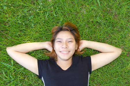 Young women sleep on grassland with her face smile の写真素材
