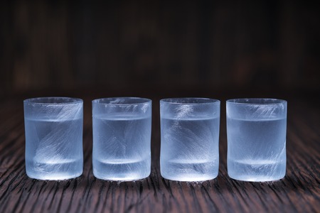 frozen vodka in small glass on wooden table, selective focusの写真素材