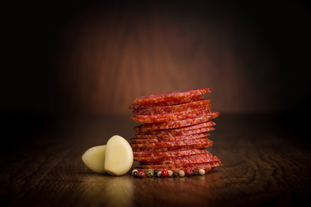 Slices of salami  on a wooden tableの写真素材
