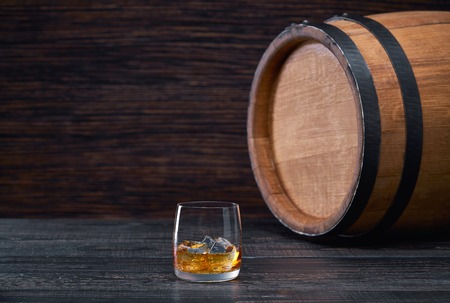 whiskey with ice on a wooden table on a  black wooden tableの写真素材